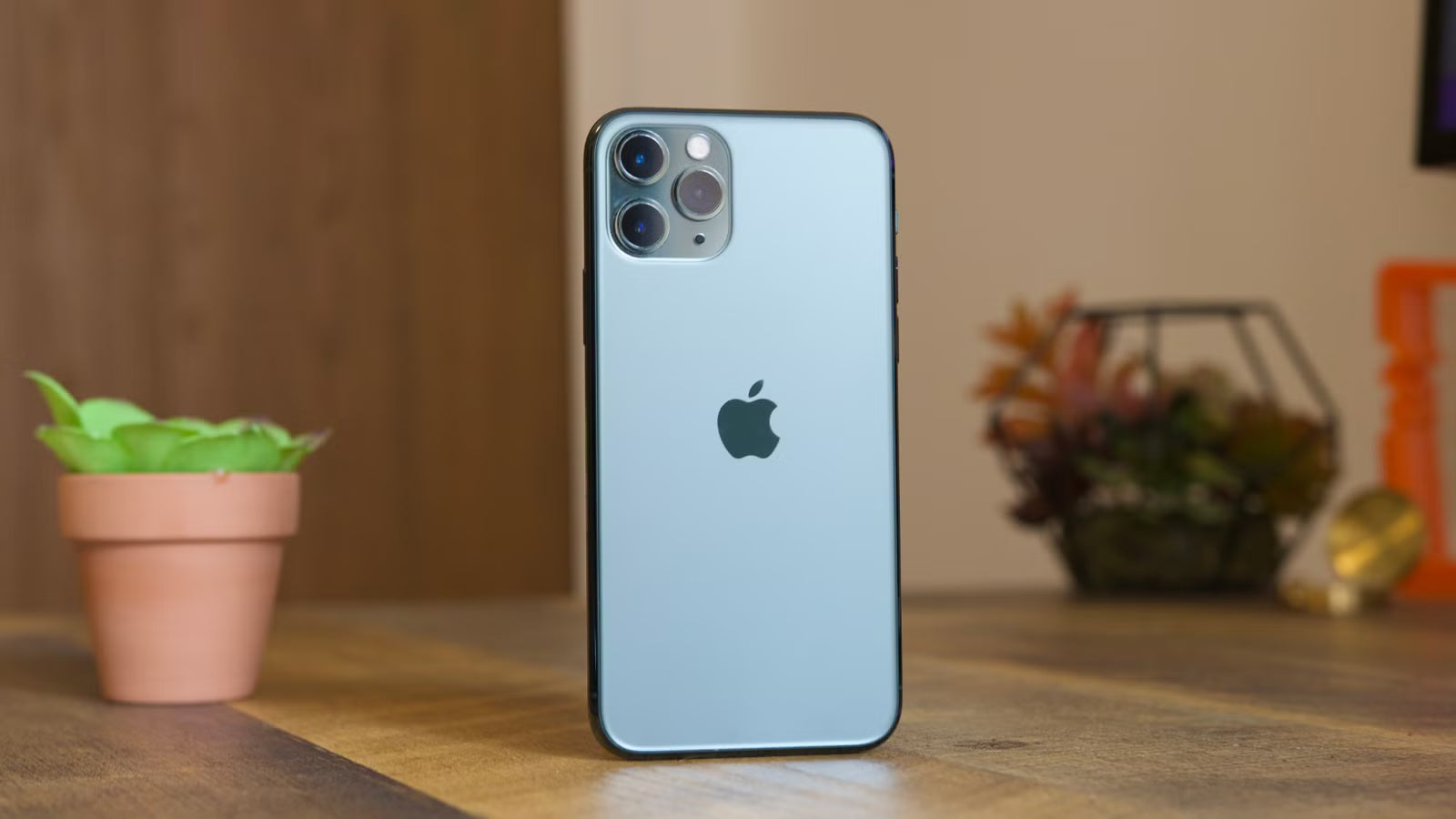 iphone 11 pro en un escritorio con articulos en el fondo