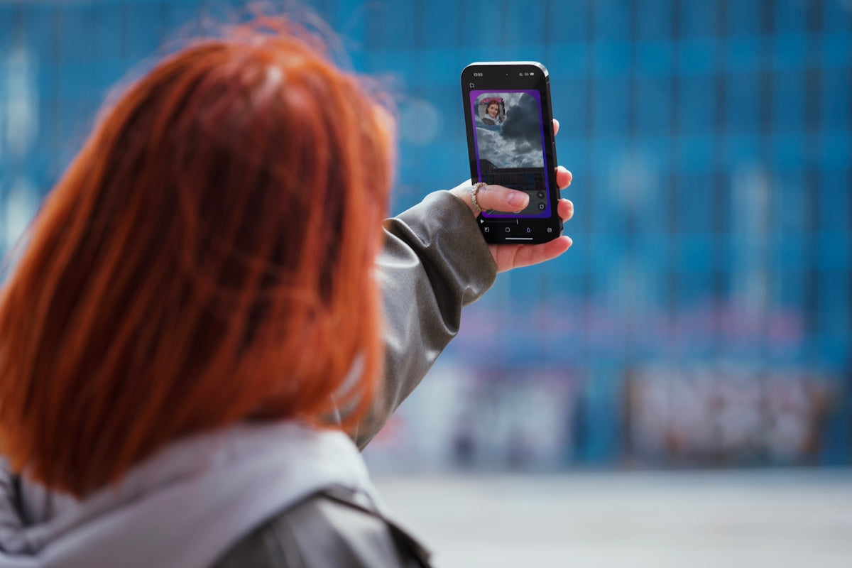 Woman with red hair taking a selfie with phone