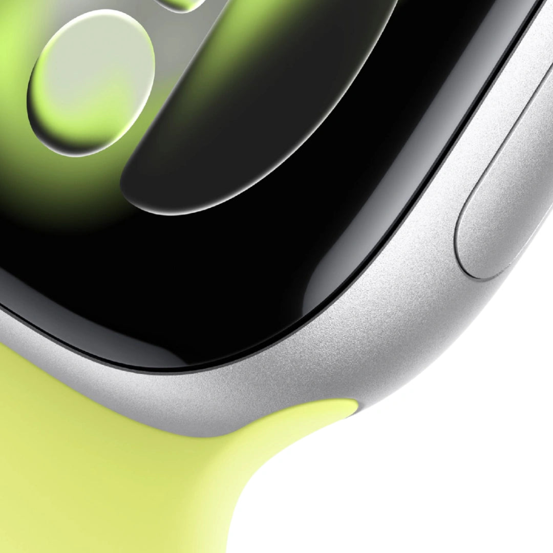 Primer plano macro del Apple Watch Plata, destacando el acabado de aluminio, el cristal curvo de la pantalla y el ajuste de la correa deportiva amarillo lima.
